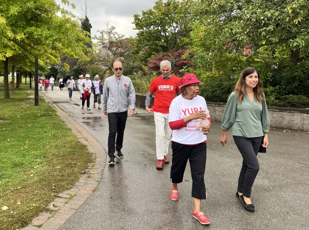 Agnes Fraser and Marisa Barlas walk near the University Common with Steven Chuang and Art McDonald behind them.  Other YURA walkers are further back in thie photo.